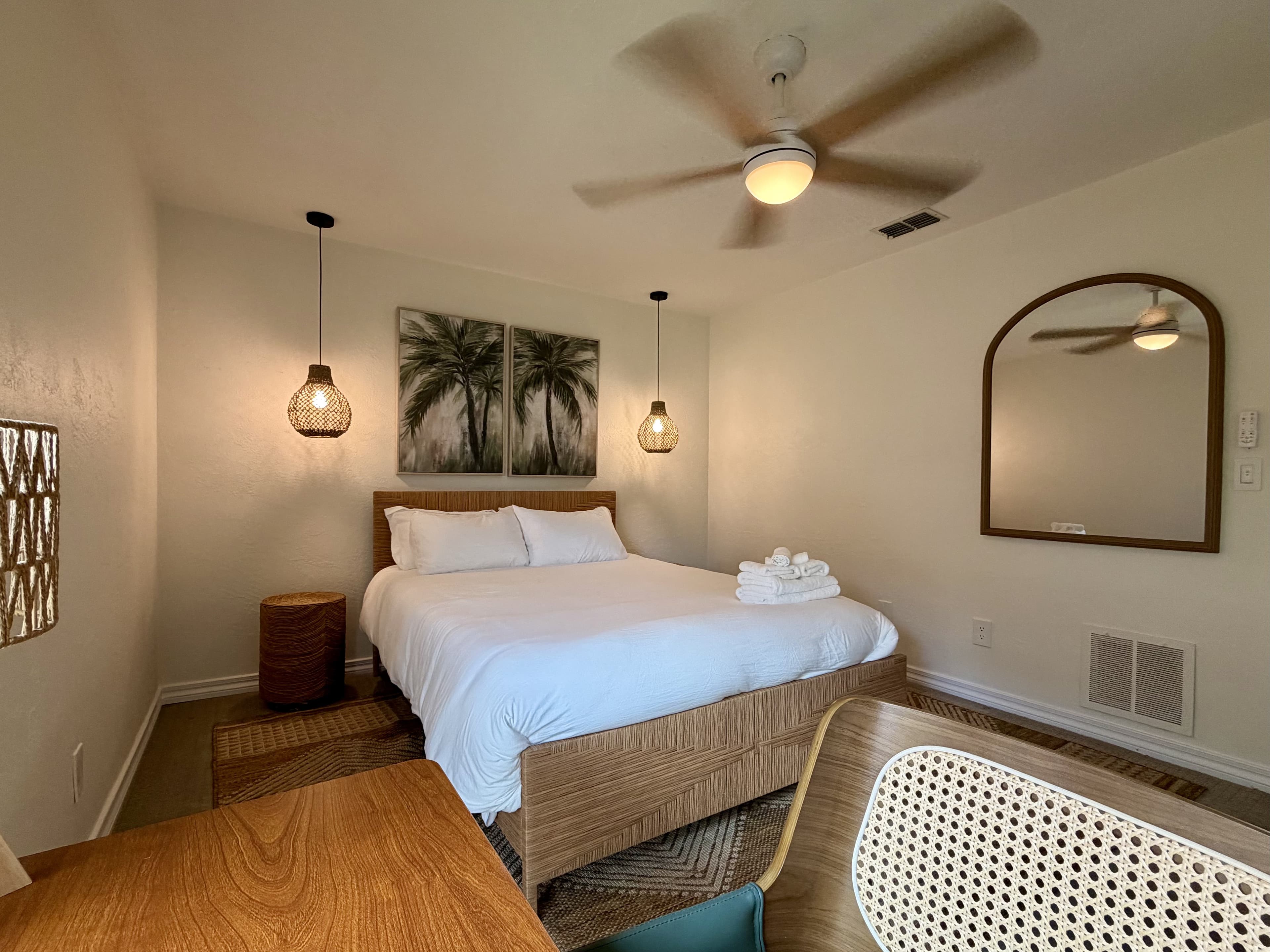 Boho bedroom with palm pendants and mirror